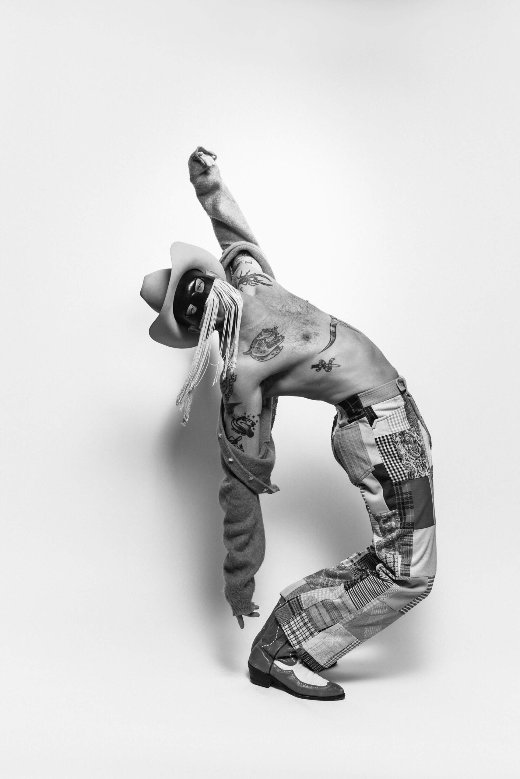 Orville Peck tattoos: grayscale full-body tattoo photograph showing the layout across chest, arms and legs