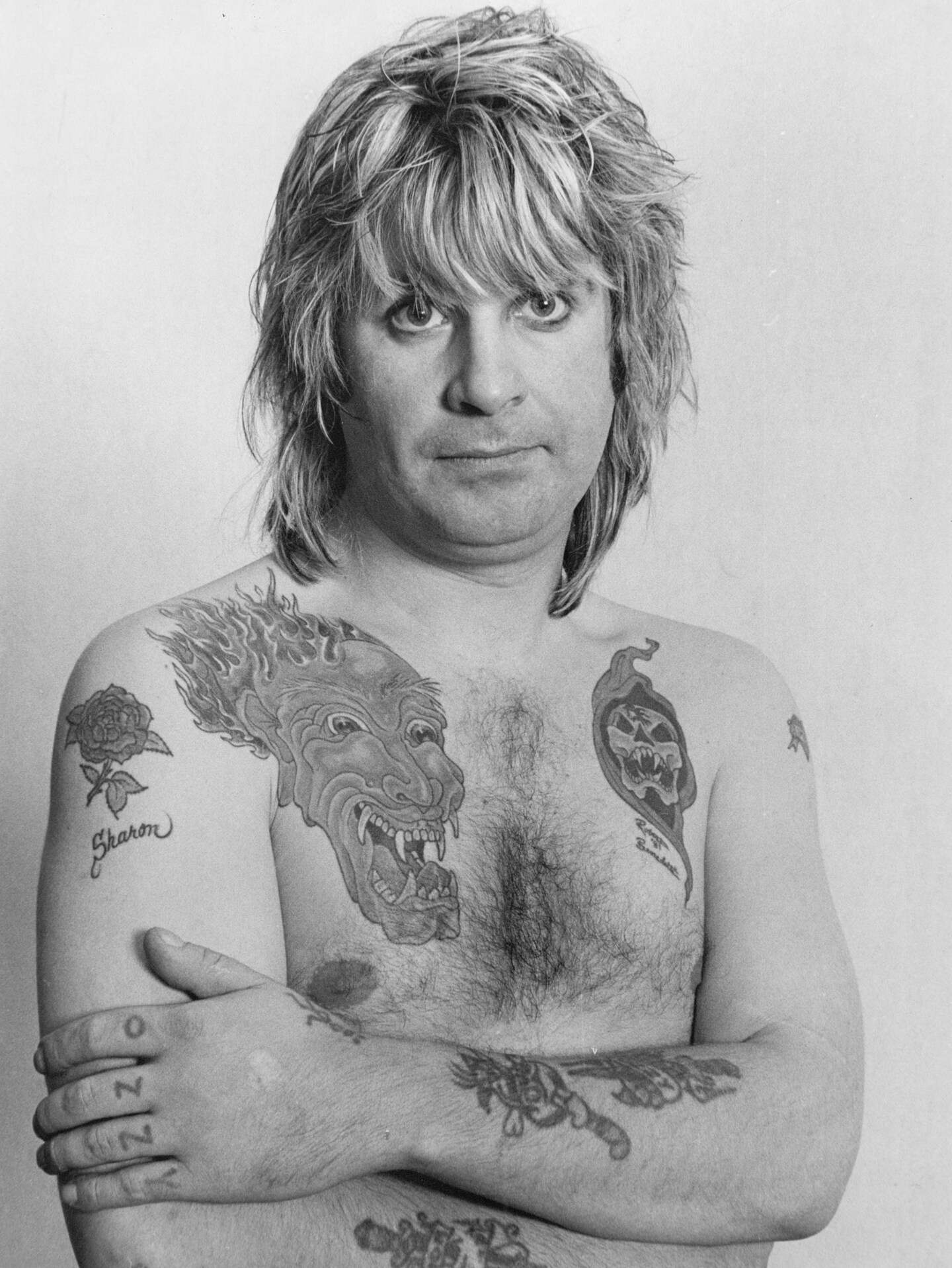 Ozzy Osbourne chest and arm tattoos visible in a black and white portrait