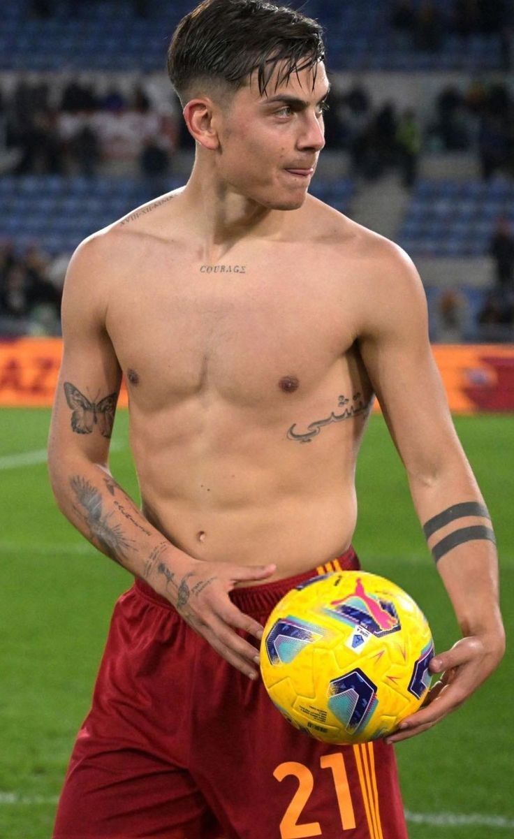 Paulo Dybala tattoos: shirtless post-match view showing the Courage chest lettering, Arabic rib script, butterfly, forearm work and black bands