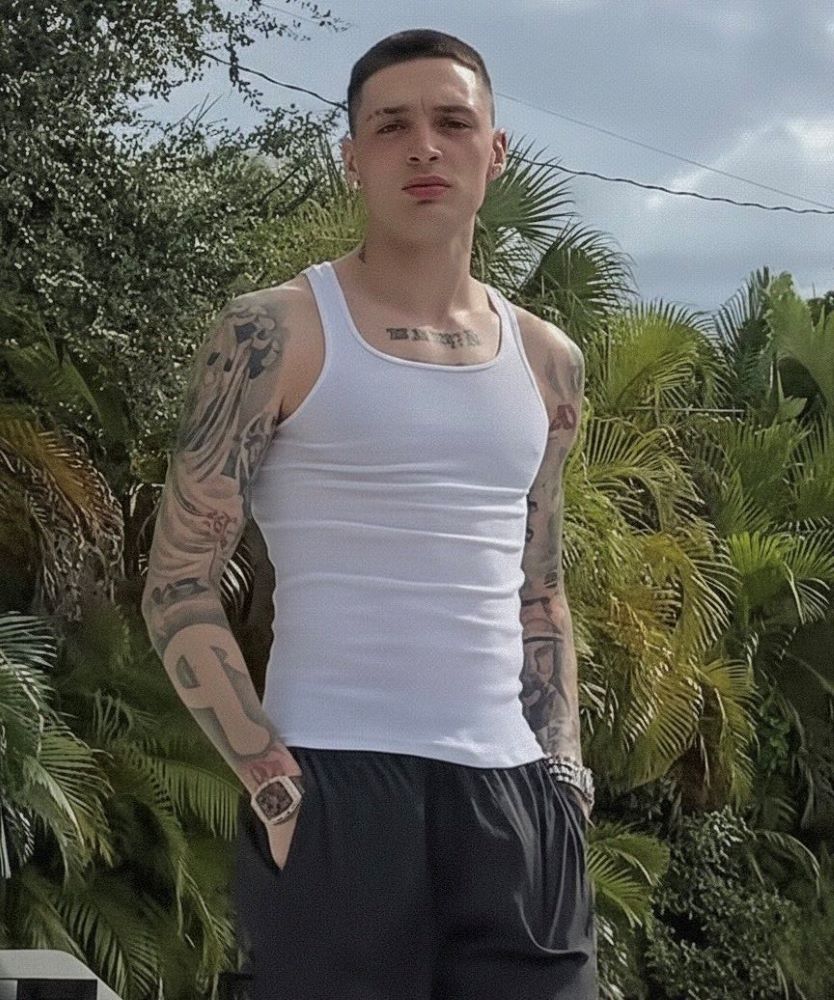Peso Pluma full arm tattoos in white tank top