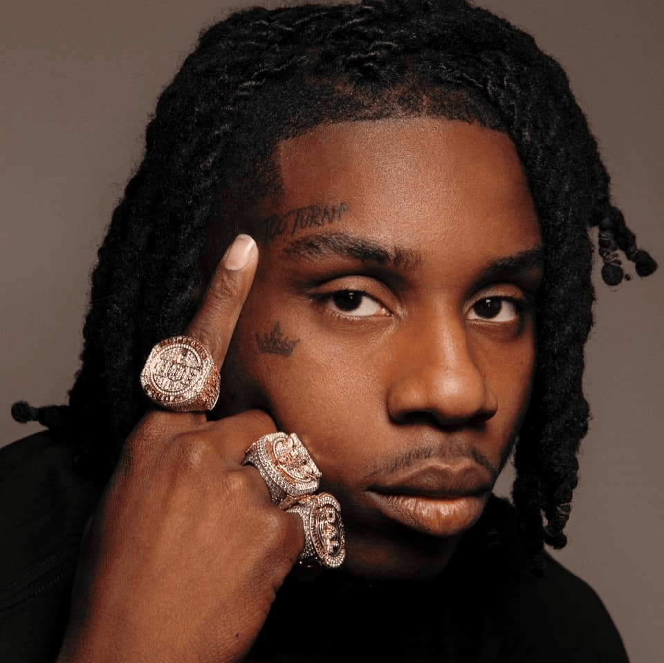 Polo G showing the tattooed arms connected to his statement ink