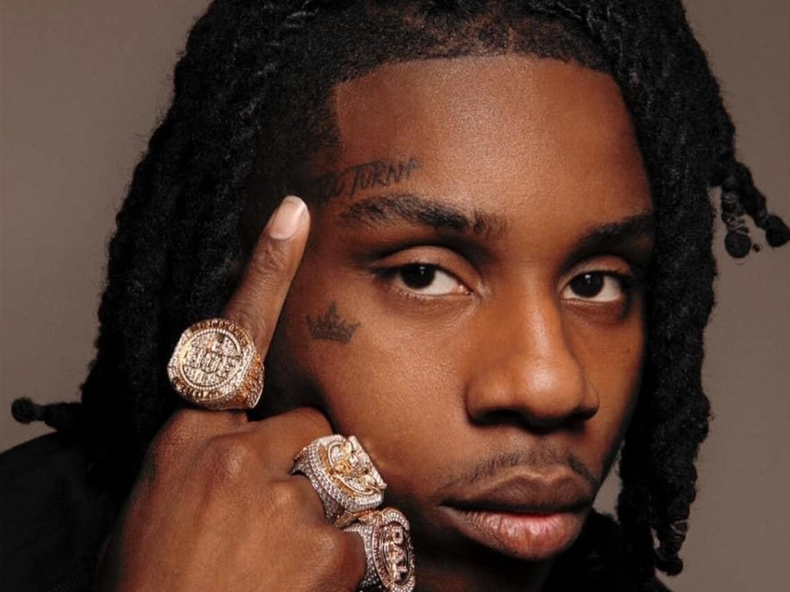 Polo G showing his face and shaded arm tattoos