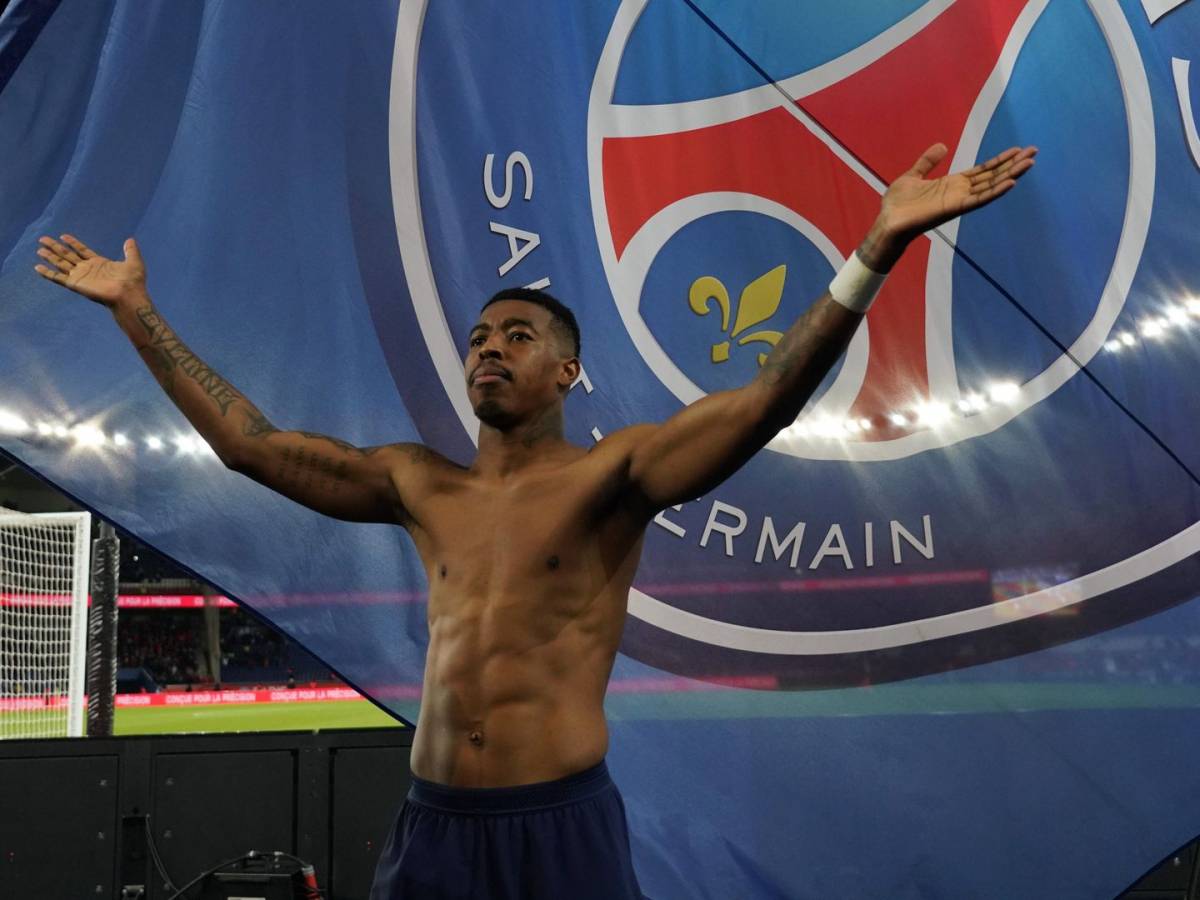 Presnel Kimpembe tattoos: Shirtless public photograph showing both arms and upper torso tattoos against the PSG crest