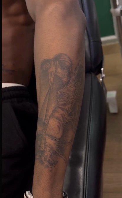 Rema tattoos: inline chariot horse and soldier arm tattoo image