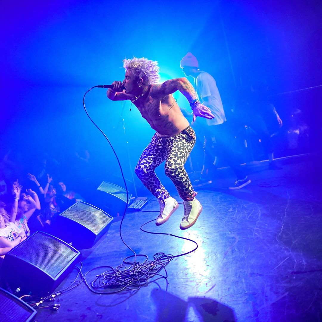 Mod Sun tattoos: script and illustrated tattoos across the torso during a live set