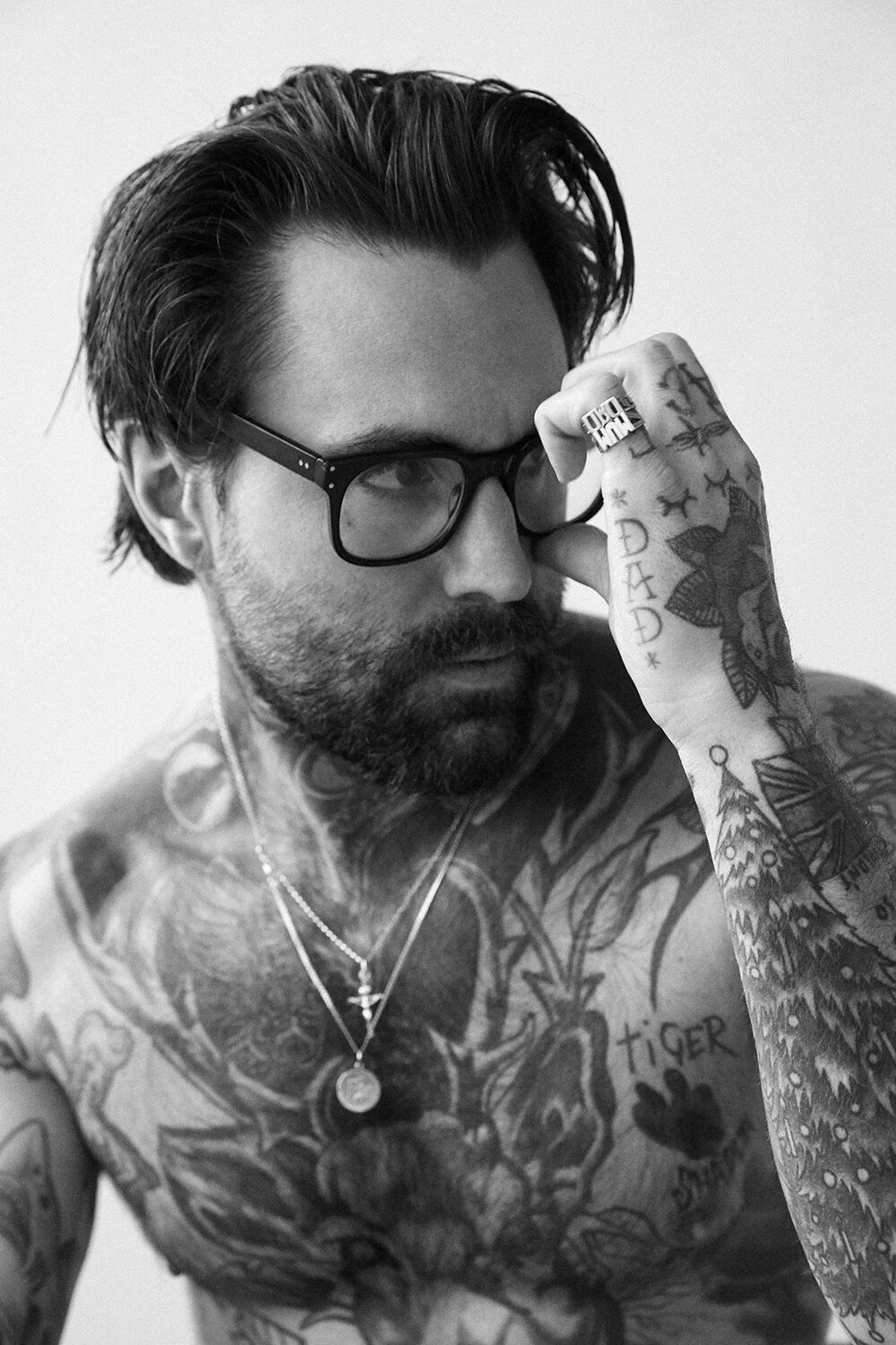 Ricki Hall tattoos: high-resolution monochrome portrait showing Ricki Hall face-on with the full chest, neck and forearm coverage visible