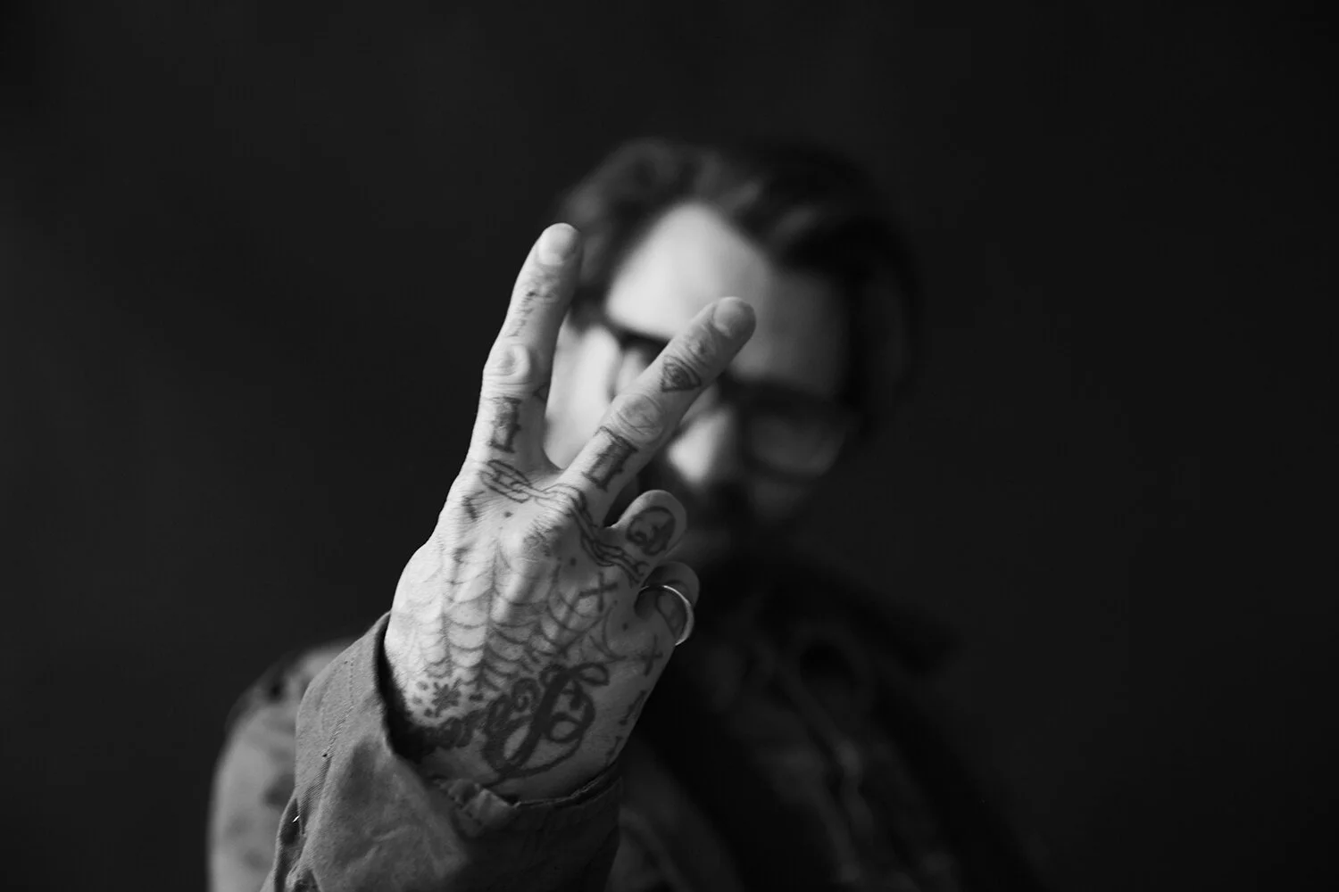 Ricki Hall tattoos: close hand portrait where the finger lettering, palm marks and wrist designs are the clear subject