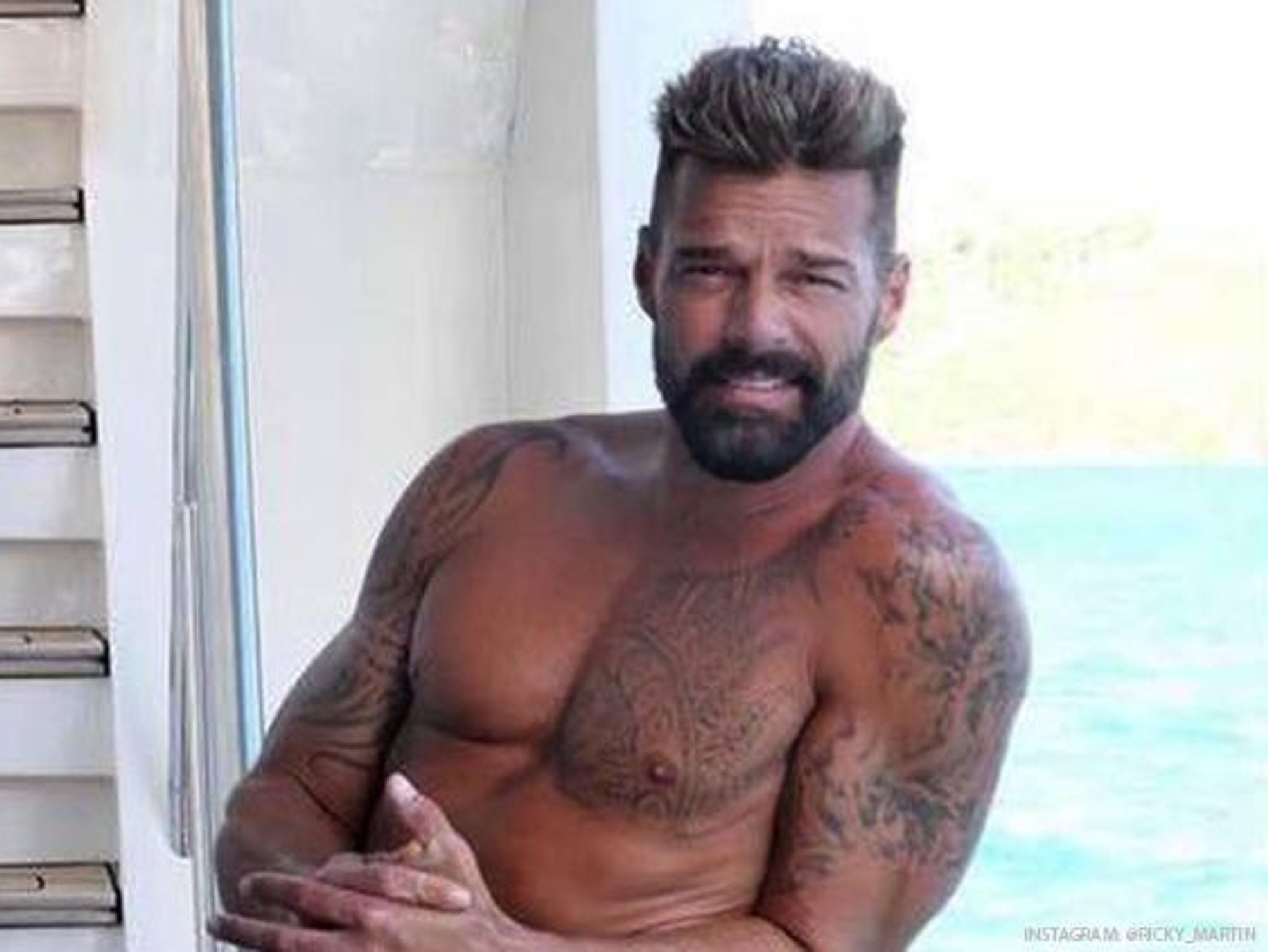 Ricky Martin showing chest and arm tattoos