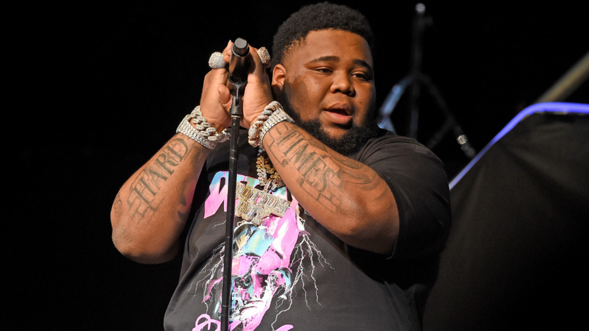 Rod Wave tattoos: the forearm lettering during a live performance
