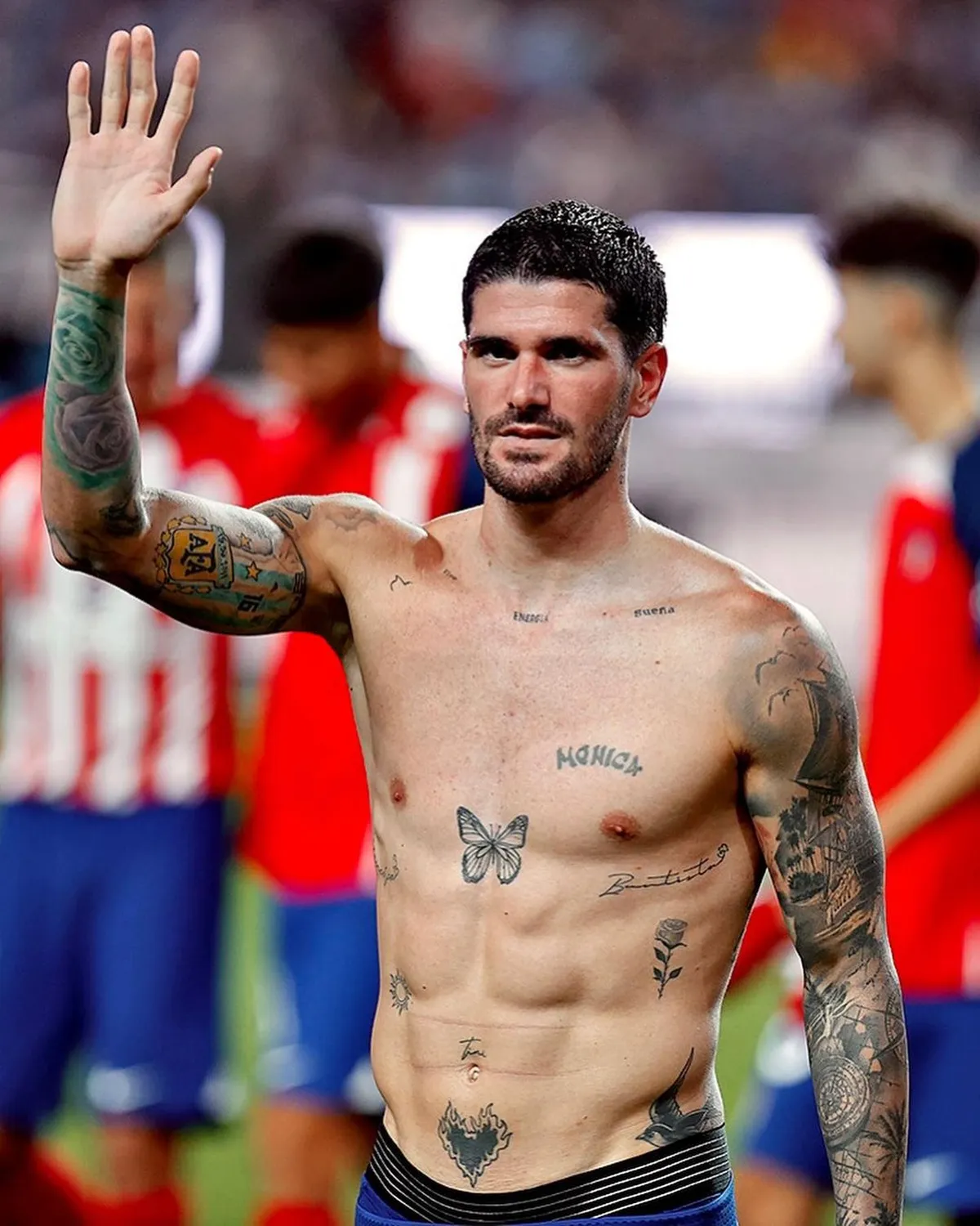 Rodrigo De Paul tattoos: clean shirtless portrait showing the butterfly on the chest, Monica lettering and tattoo coverage across both arms