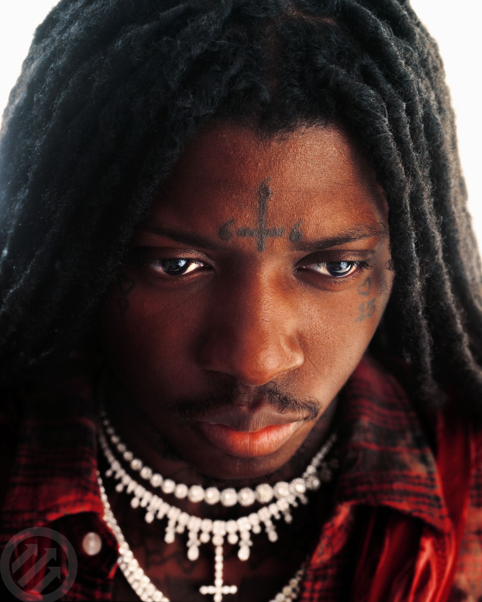 SahBabii tattoos: high-resolution close-up showing the forehead cross and small cheek tattoos