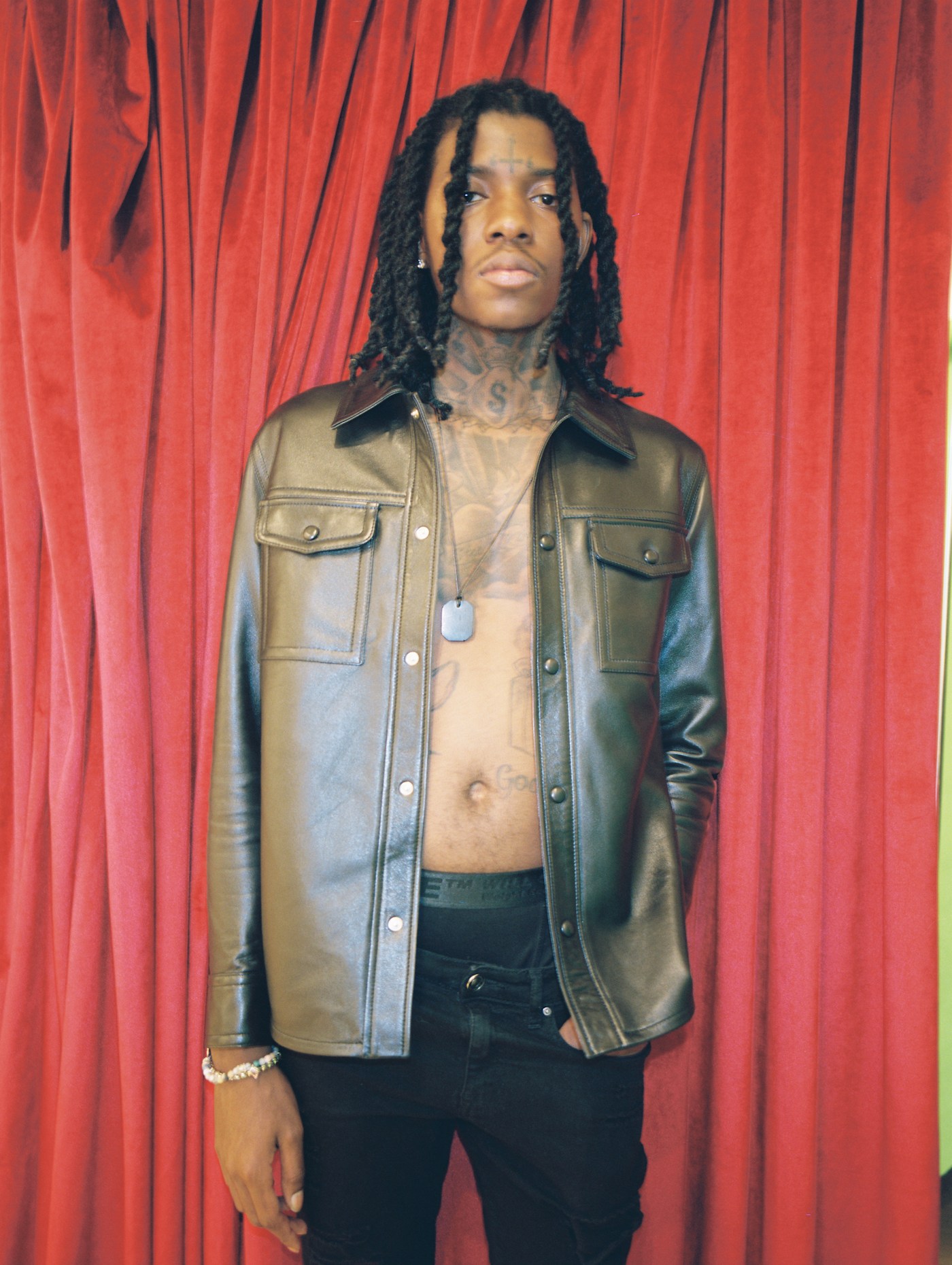 SahBabii tattoos: high-resolution red-curtain portrait showing the neck tattoo, forehead cross and open chest