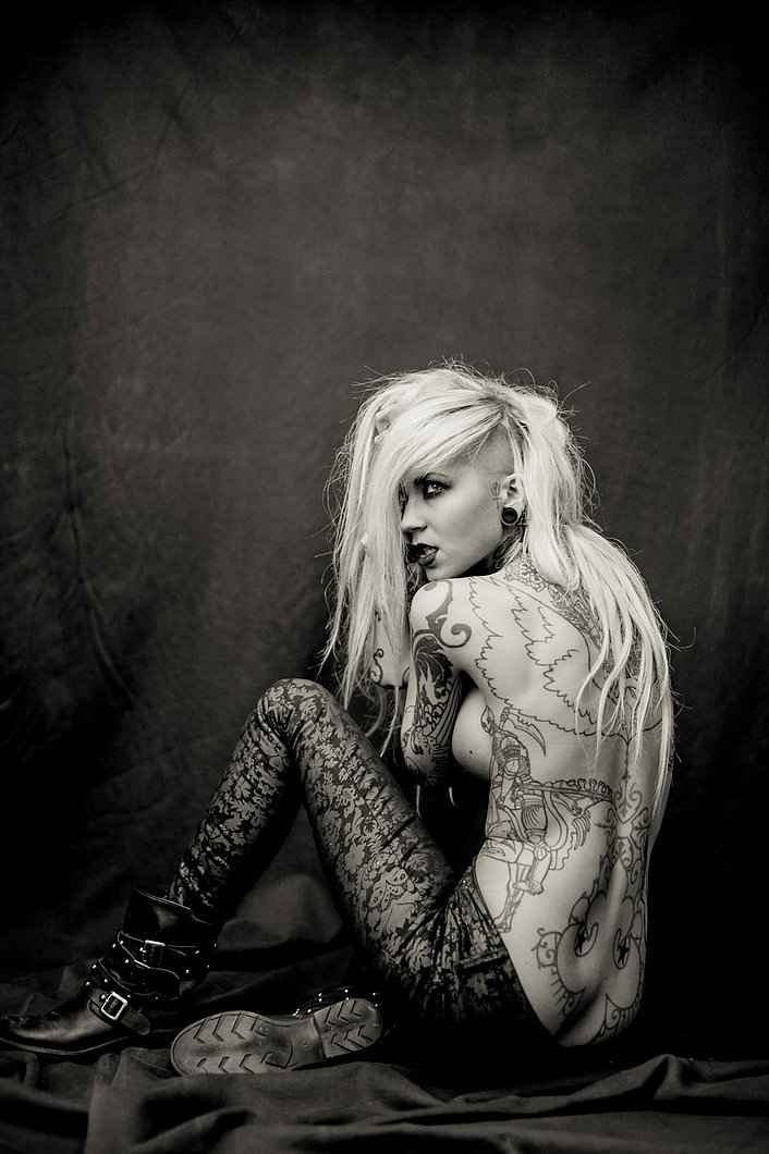 Sara Fabel tattoos: Upper back wing outlines visible and sharp; fine contours and large open spaces.