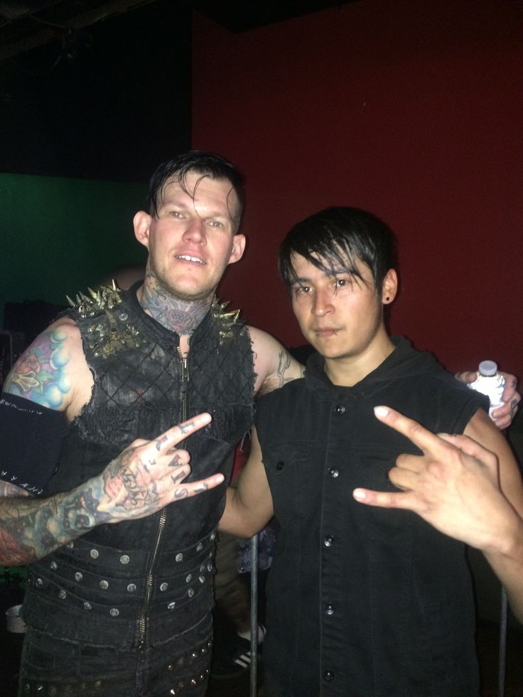 Scott Lewis showing his arm, hand, and neck tattoos