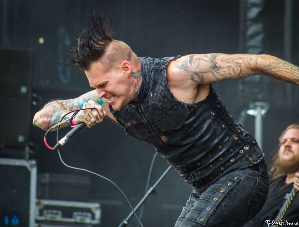 Scott Lewis showing his arm tattoos during a Carnifex performance