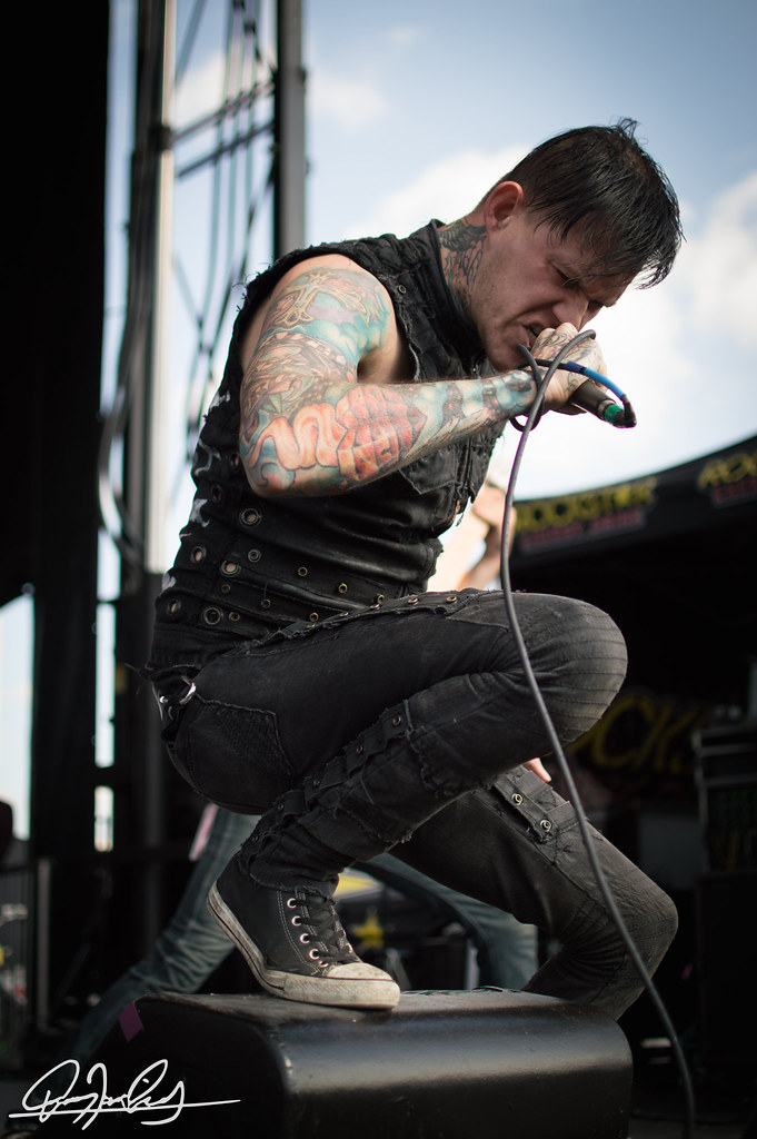 Scott Lewis showing his sleeve tattoos during a performance