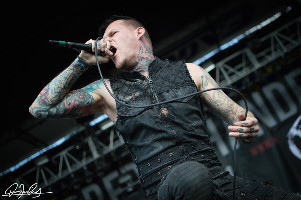 Scott Lewis showing his sleeve and hand tattoos while performing
