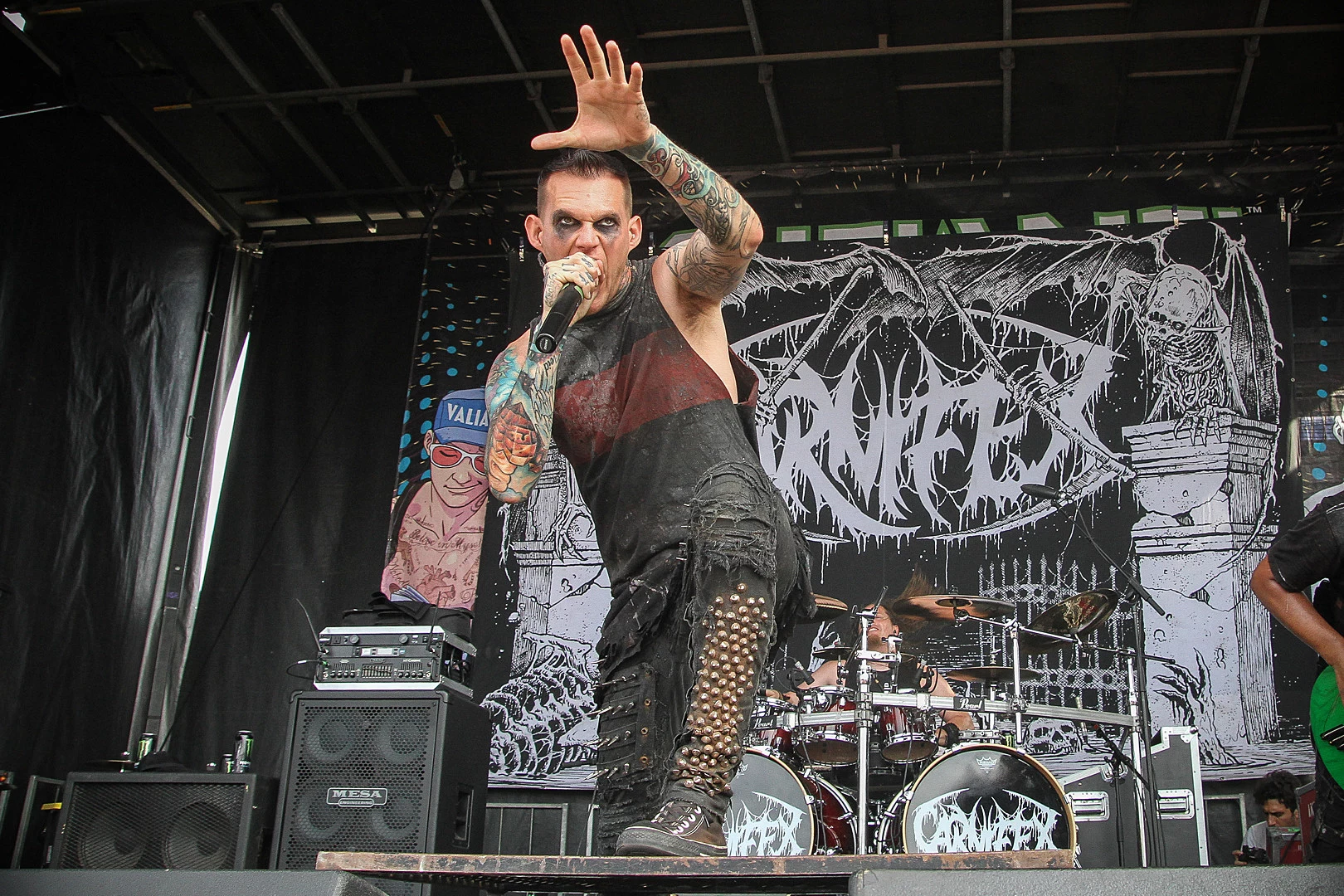 Scott Lewis showing his tattooed arms on stage