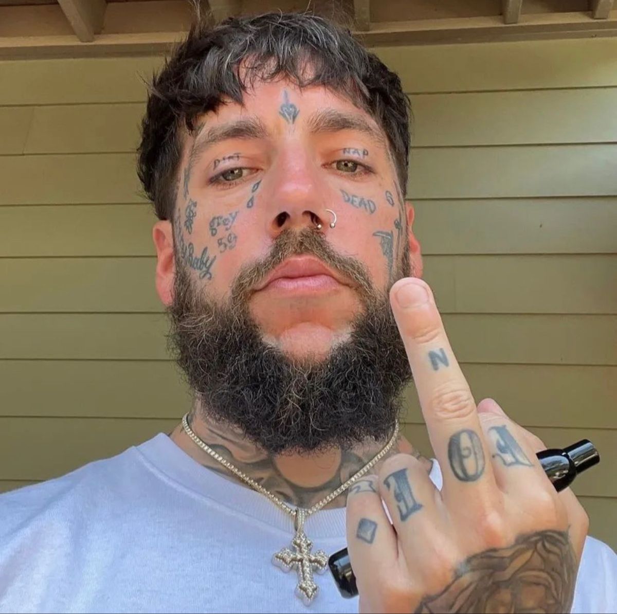 Scrim tattoos: a sharp face and hand close-up showing letters and symbols