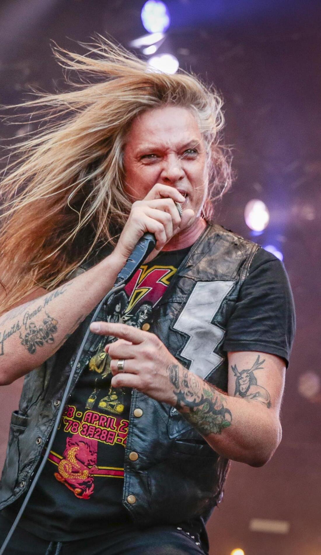 Sebastian Bach forearm tattoos in a vertical stage portrait