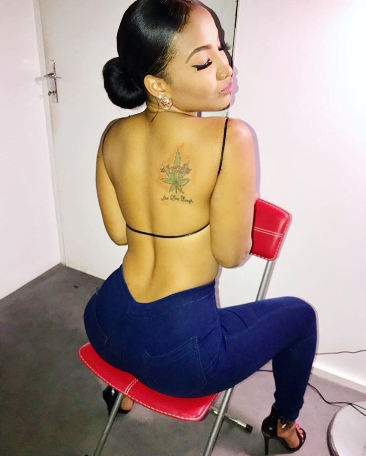Shenseea upper-back Live Love Laugh tattoo Shenseea tattoos: Shenseea's upper-back cannabis leaf tattoo
