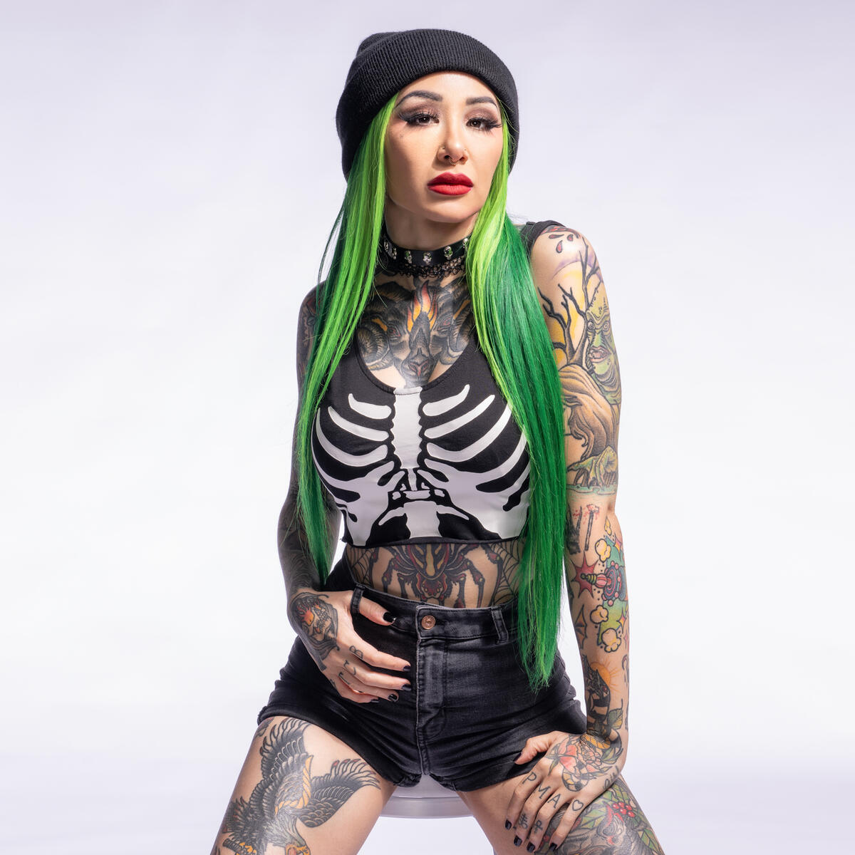 Shotzi seated leg tattoos