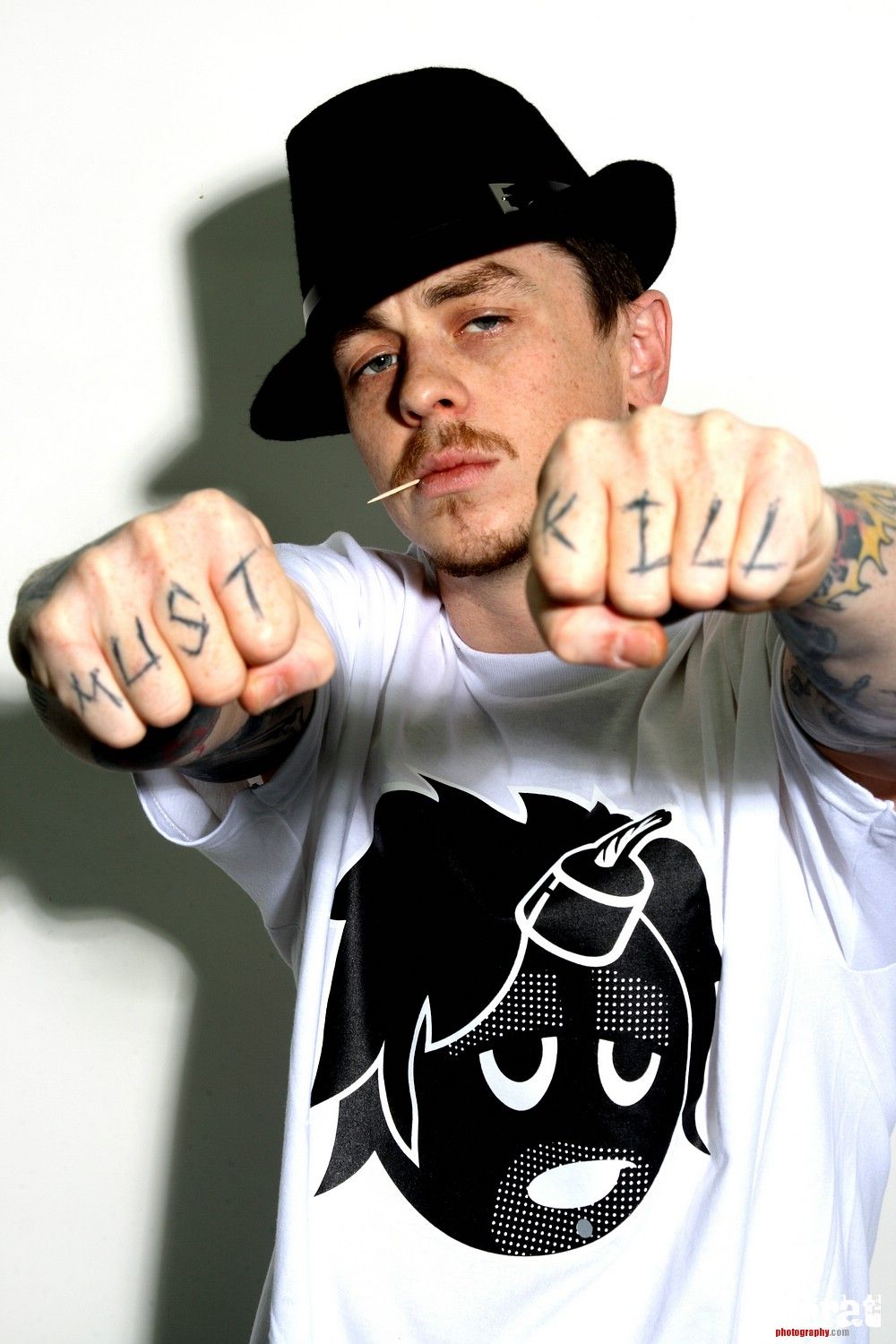 Sid Wilson tattoos: high-resolution portrait clearly showing the MUST KILL knuckles and colorful sleeve work