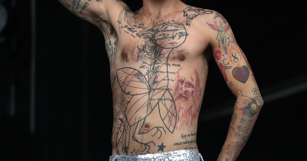 Simon Neil stage chest and arm tattoos