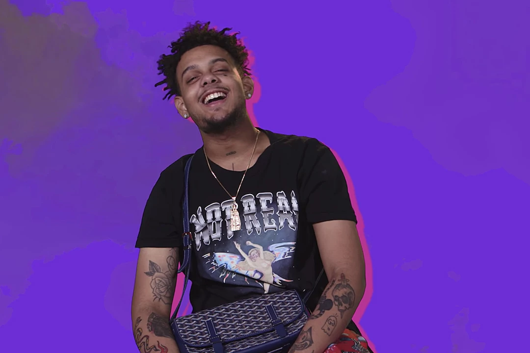 Smokepurpp tattoos: high-resolution portrait showing tattooed arms and visible neck ink at a media appearance