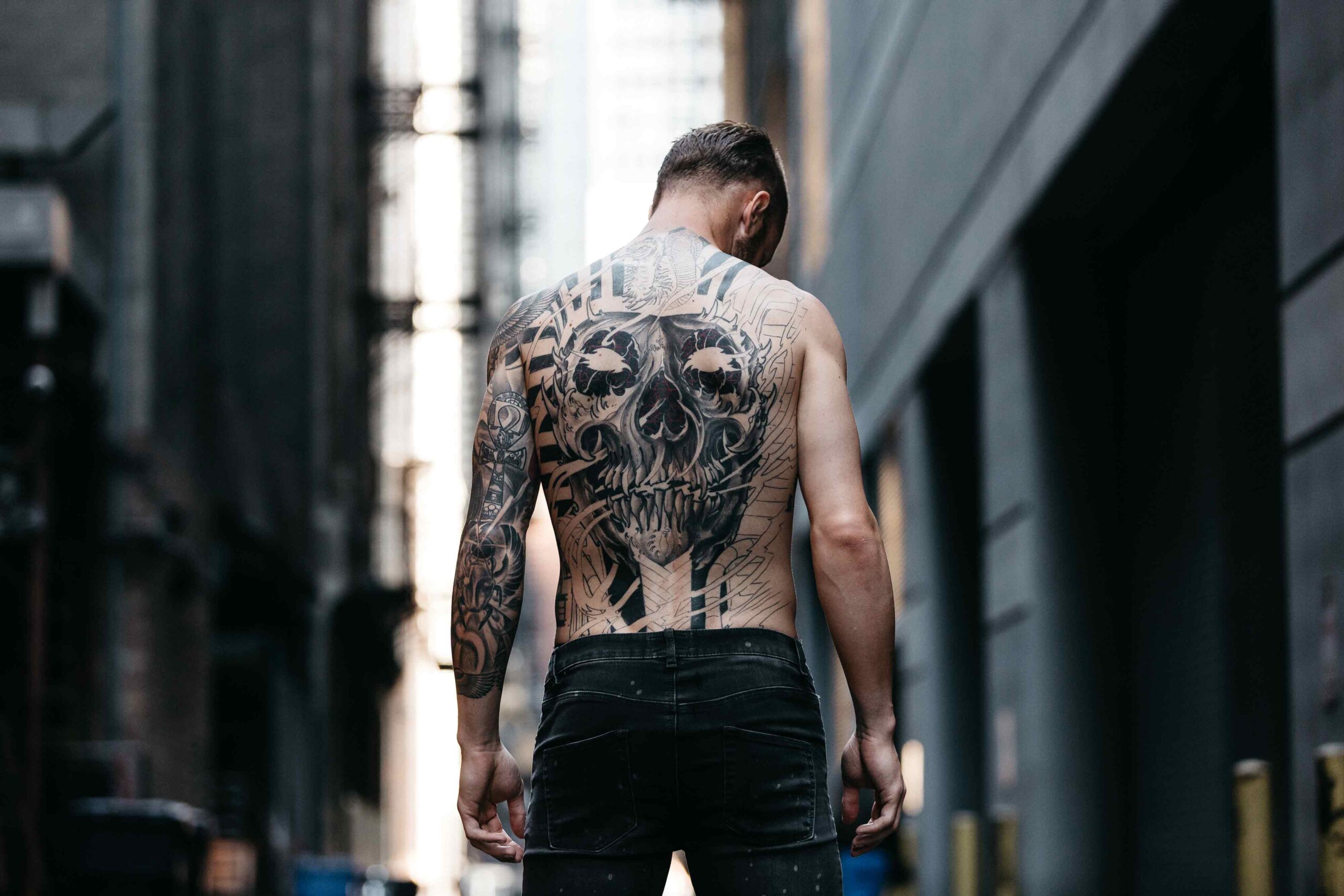 Stefan Frei tattoos: full-back Egyptian skull tattoo and left-arm sleeve in a rear walking portrait