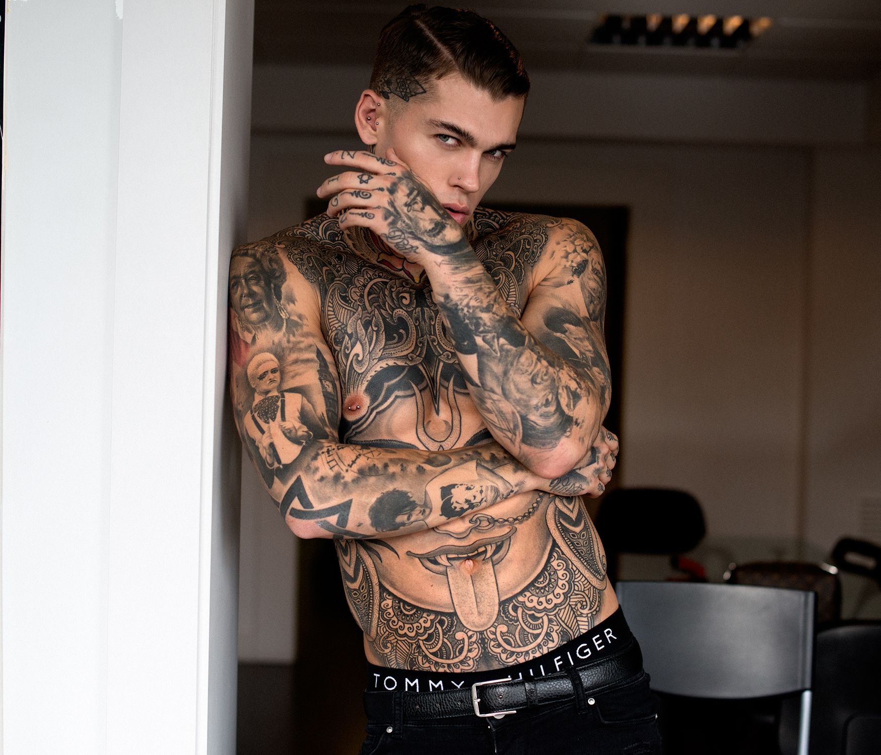Stephen James tattoos: Ornamental chest curves and tongue-and-teeth stomach design