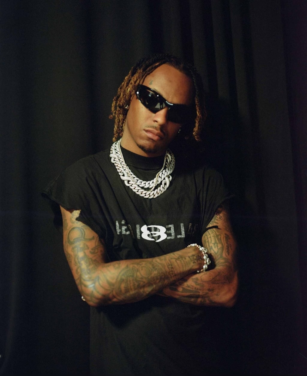 Rich The Kid tattoos: dense arm and shoulder ink in a studio portrait