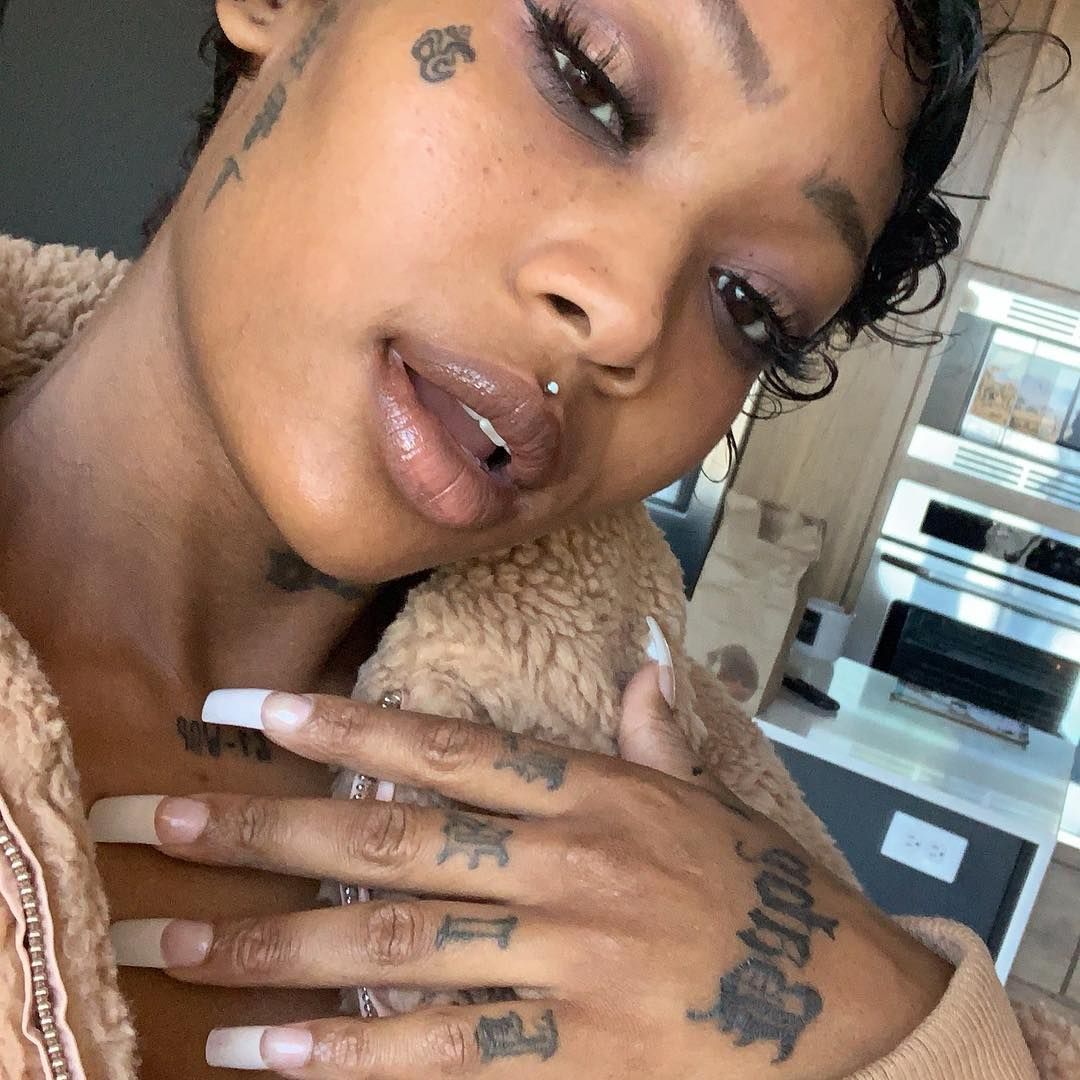 Summer Walker tattoos: Summer Walker close selfie showing face and hand tattoos