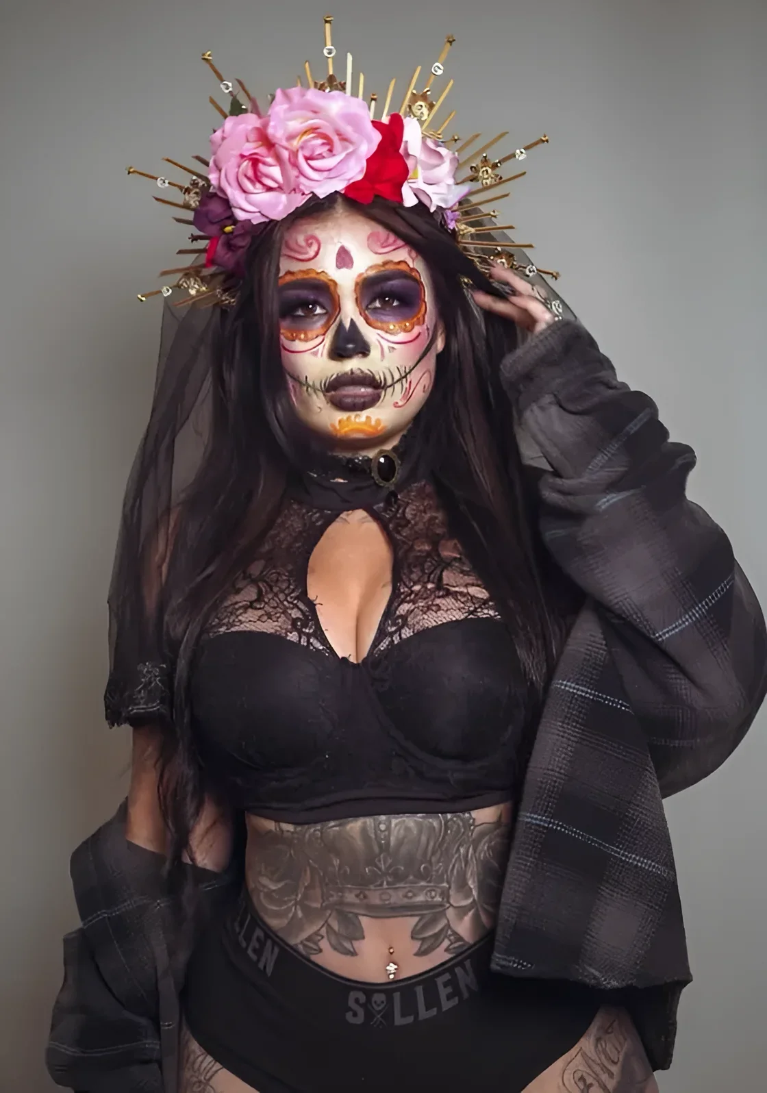 Tatu Baby tattoos: Tatu Baby sugar-skull makeup and stomach tattoos, selected because the named tattoo areas are plainly visible in a distinct high-resolution photograph