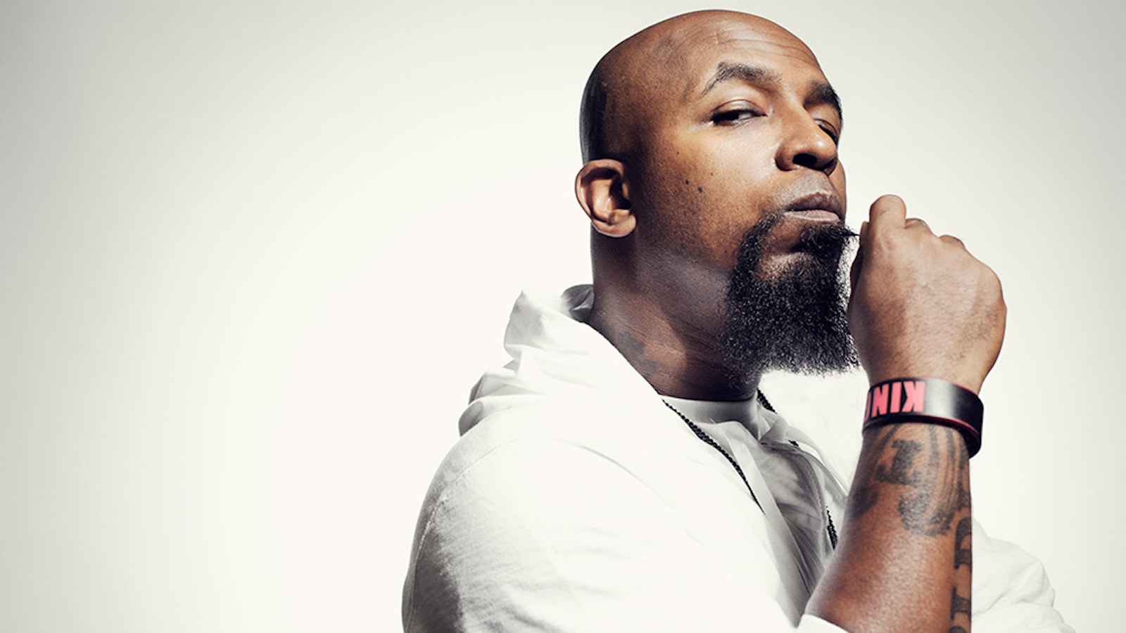 Tech N9ne tattoos: portrait showing the LIBERATE ME lettering and additional forearm ink