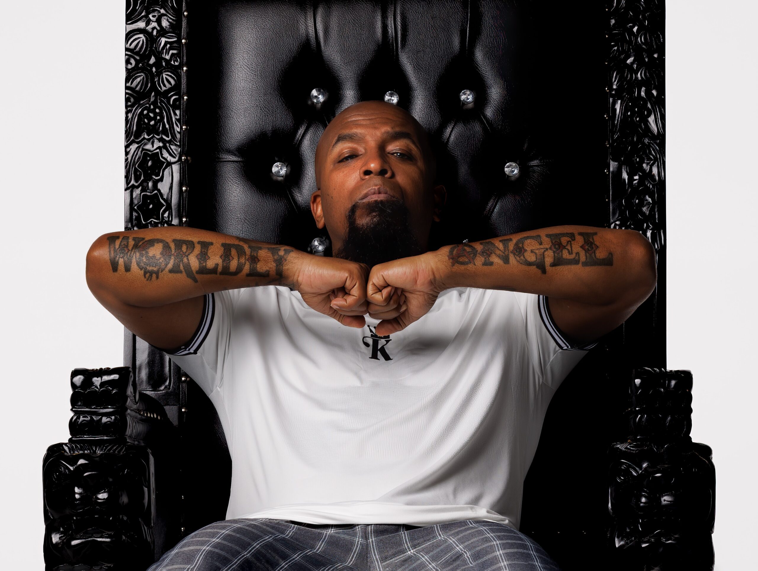 Tech N9ne tattoos: high-resolution portrait clearly showing the WORLDLY and ANGEL forearm lettering