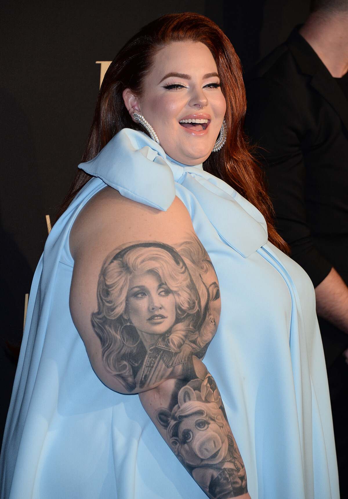 Tess Holliday Dolly Parton and Miss Piggy portraits visible on the arm at a red-carpet event Tess Holliday tattoos: Dolly Parton and Miss Piggy portraits visible on the arm at a red-carpet event