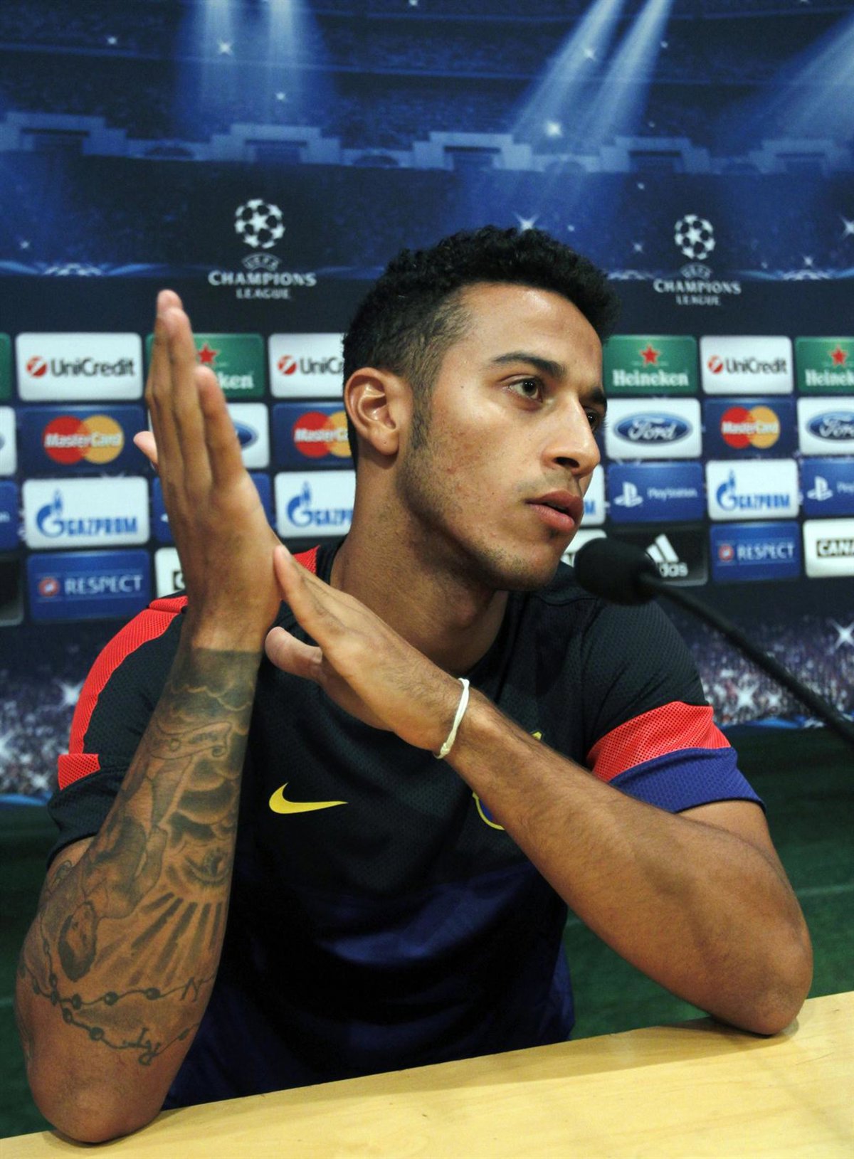 Thiago Alcántara tattoos: right-arm sleeve detail in a separate 2013 press-conference photograph