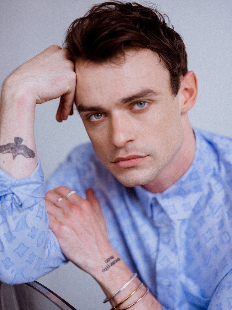 Thomas Doherty tattoos: Thomas Doherty close portrait with the love yourself wrist tattoo visible
