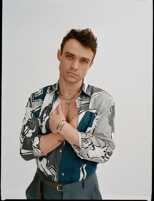Thomas Doherty tattoos: Thomas Doherty portrait with chest and wrist tattoos visible