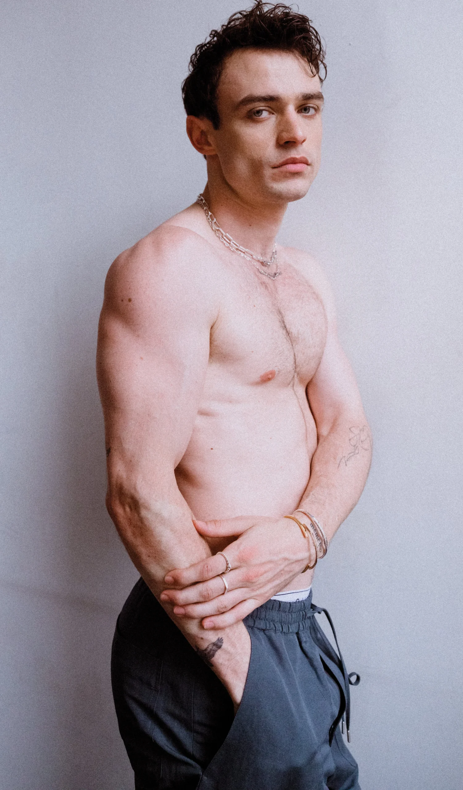 Thomas Doherty tattoos: Thomas Doherty shirtless portrait with wrist and forearm tattoos visible