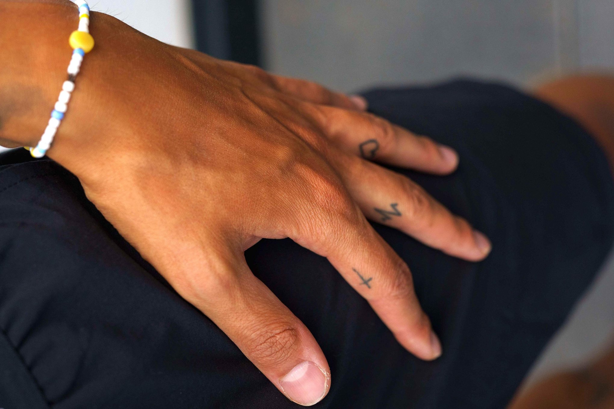 Tim Kühnel tattoos: Close-up documenting the small hand and finger tattoos shown in the gallery