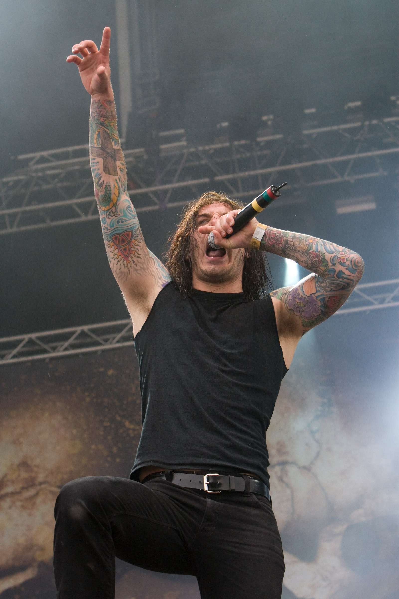 Tim Lambesis showing both colorful tattooed arms in a close stage photo