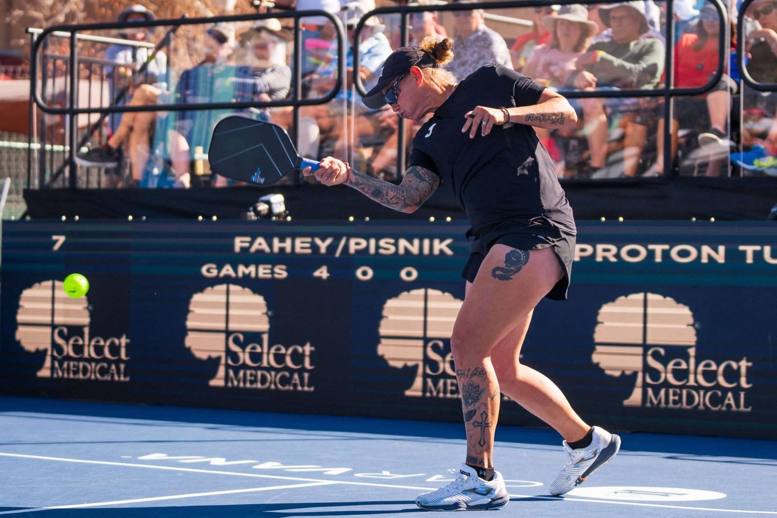 Tina Pisnik tattoos: arm and leg symbols visible during a full-body court movement