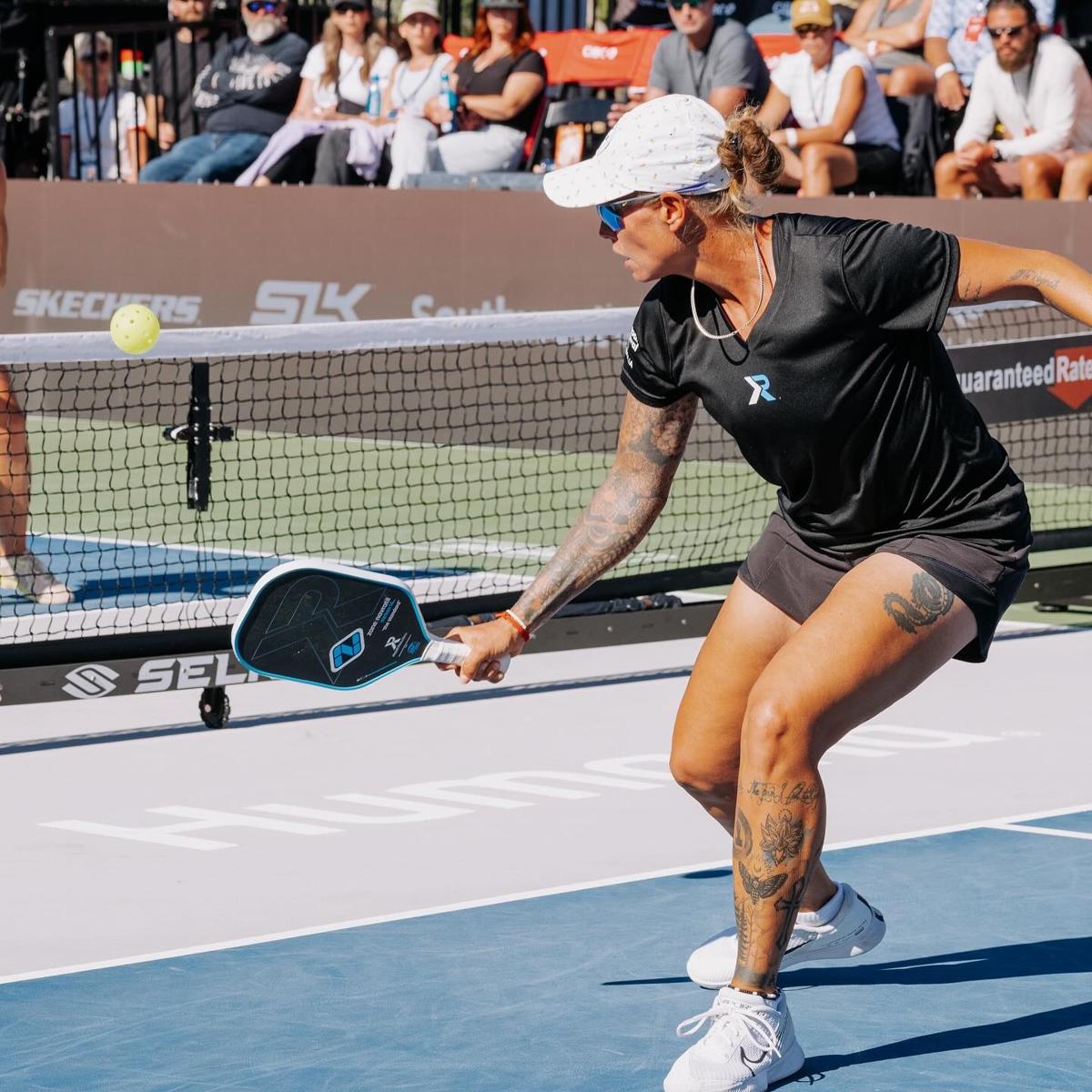 Tina Pisnik tattoos: leg placement and lower-leg tattoo coverage in a tournament photograph