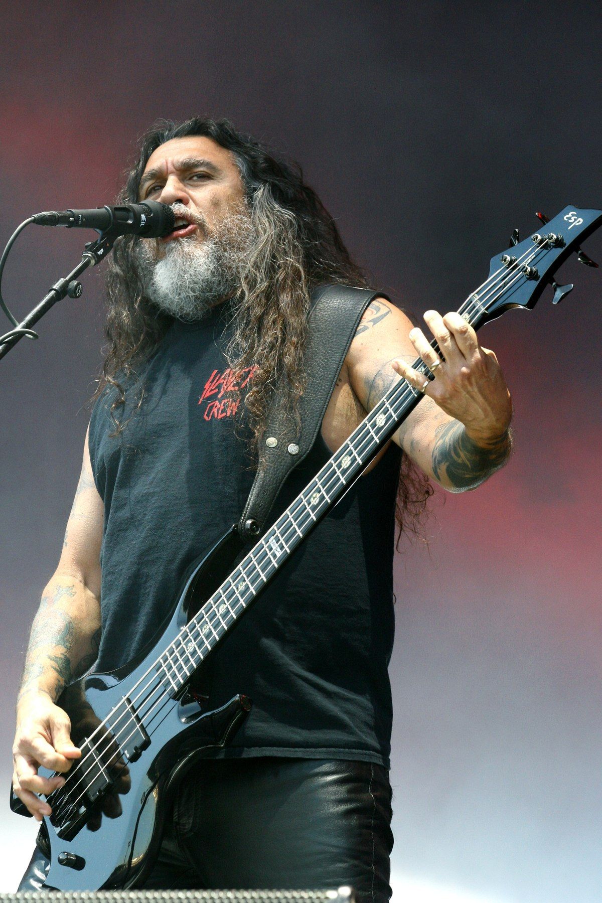 Tom Araya tattooed arms while playing bass with Slayer