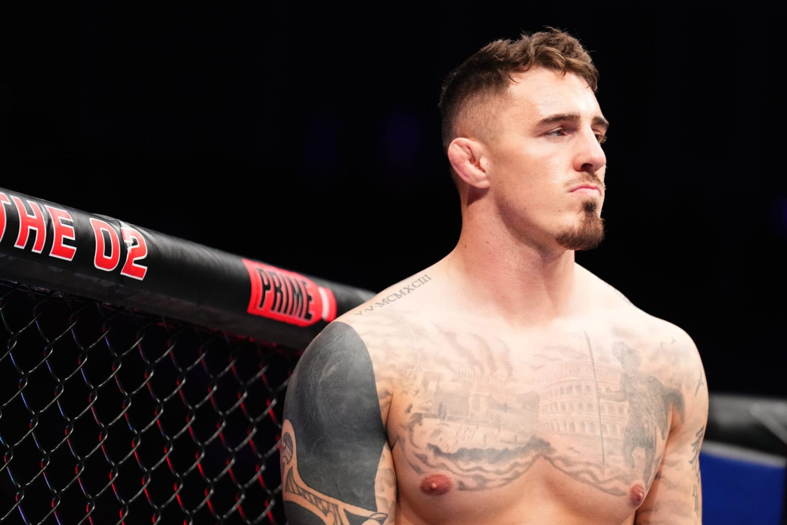 Tom Aspinall tattoos: front view showing neck, chest and surrounding arm tattoos