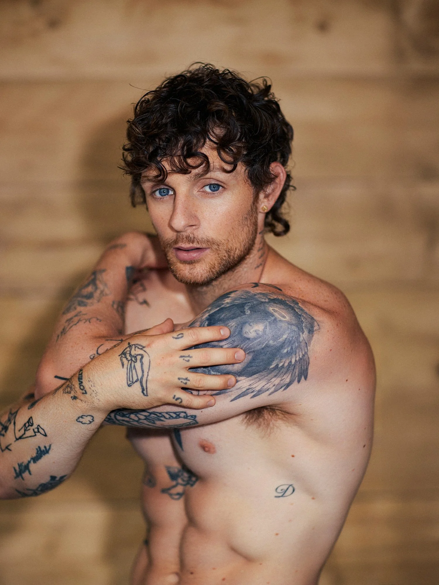 Tom Grennan tattoos: mixed flowers figures and hand marks