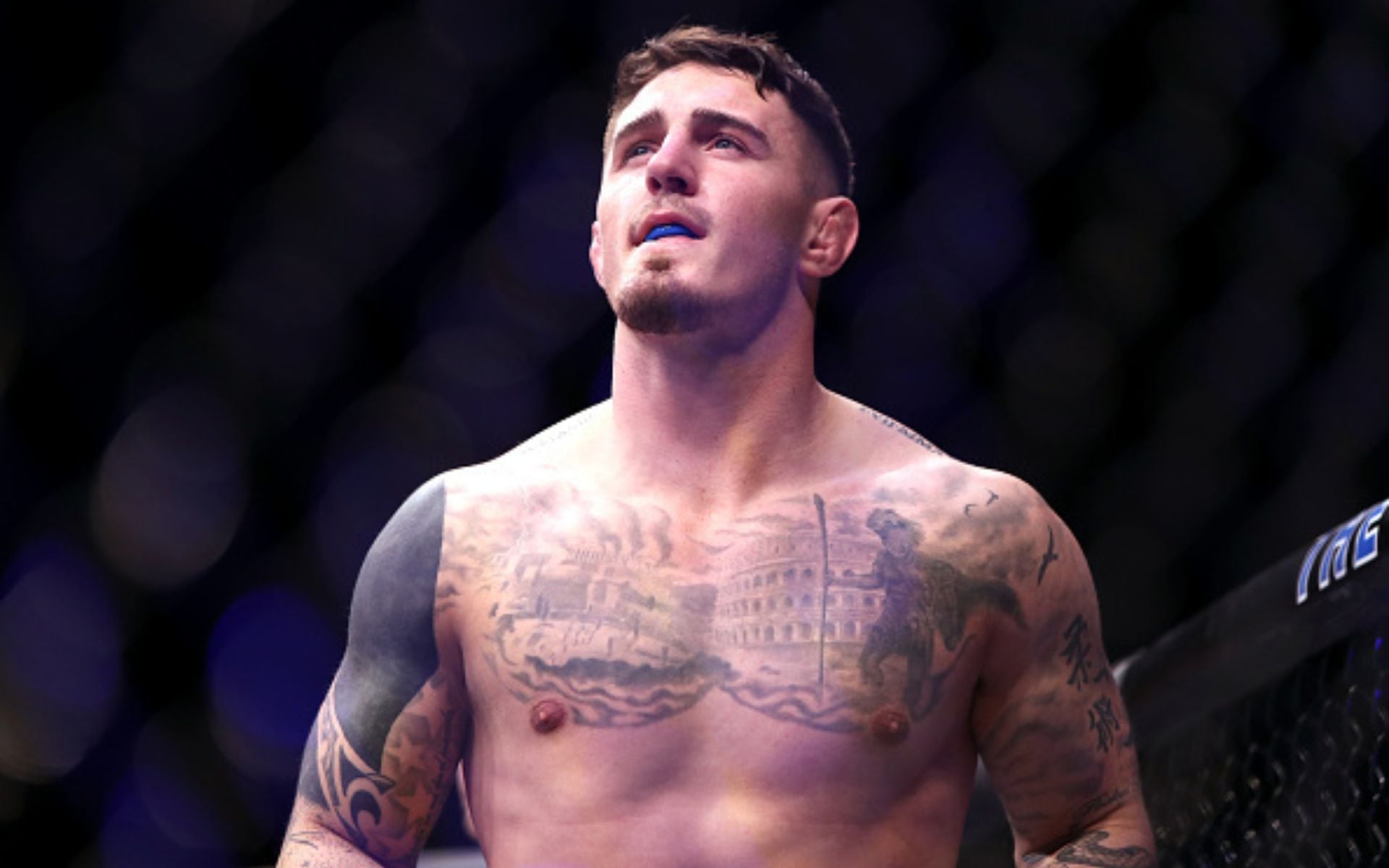 Tom Aspinall tattoos: heavy black shoulder and upper-arm cover-up work