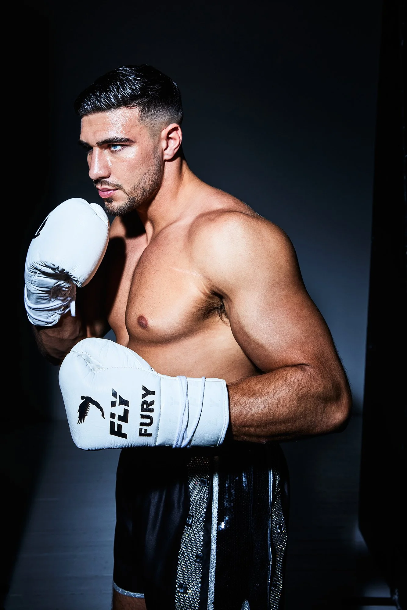 Tommy Fury in a contextual photograph: Contextual boxing portrait in gloves; not tattoo evidence.; not tattoo evidence